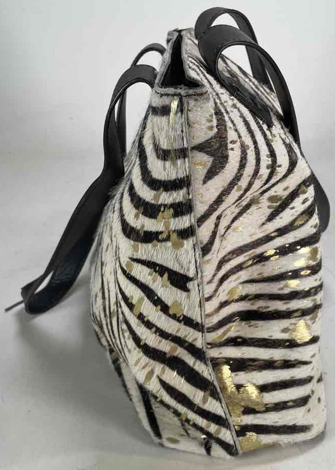 Black and cream zebra print hair-on texture tote with gold splatter and black shoulder straps, view 5