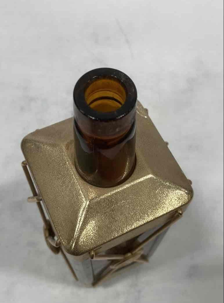 Amber glass decanter labeled Swiss Harmony Musical in a brass-tone wire caddy with medallion, view 7