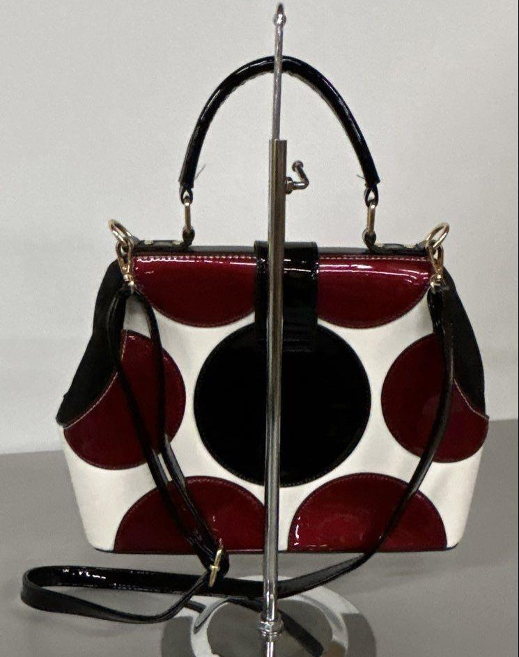 Red, black and white patent-look colorblock frame satchel with circle motifs and top handle, view 4