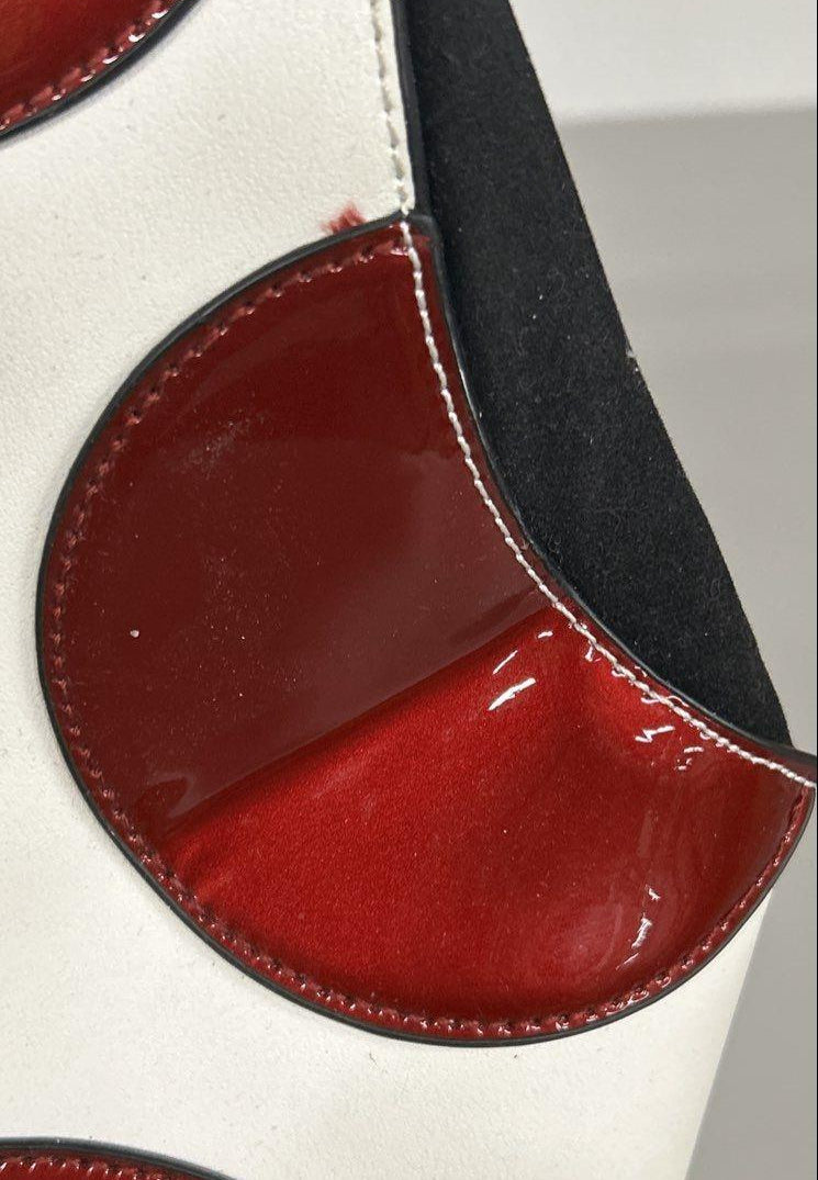 Red, black and white patent-look colorblock frame satchel with circle motifs and top handle, view 7