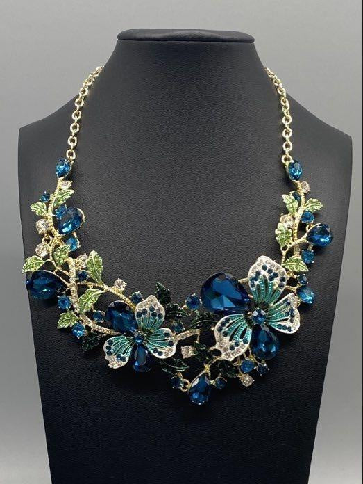 Gold-tone bib necklace of blue rhinestone flowers, leaves and turquoise enamel butterflies, view 2