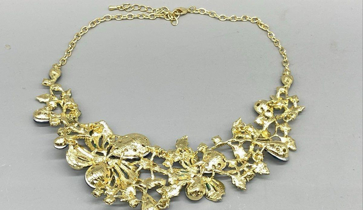 Gold-tone bib necklace of blue rhinestone flowers, leaves and turquoise enamel butterflies, view 4