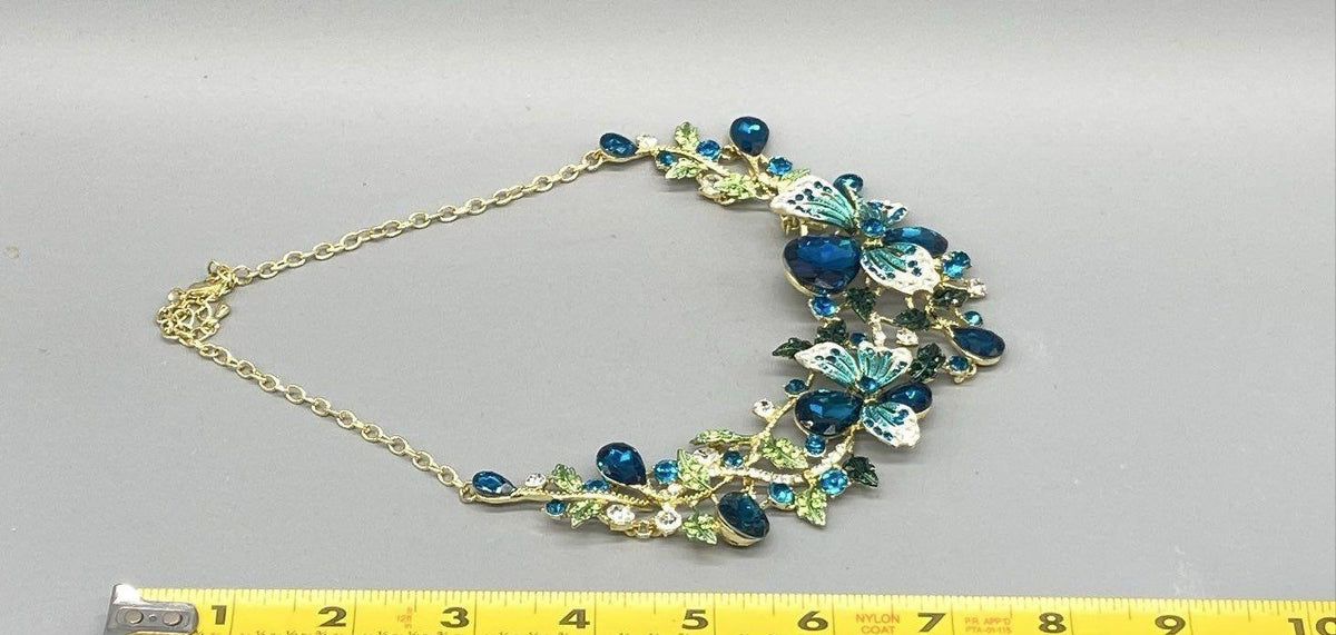 Gold-tone bib necklace of blue rhinestone flowers, leaves and turquoise enamel butterflies, view 5