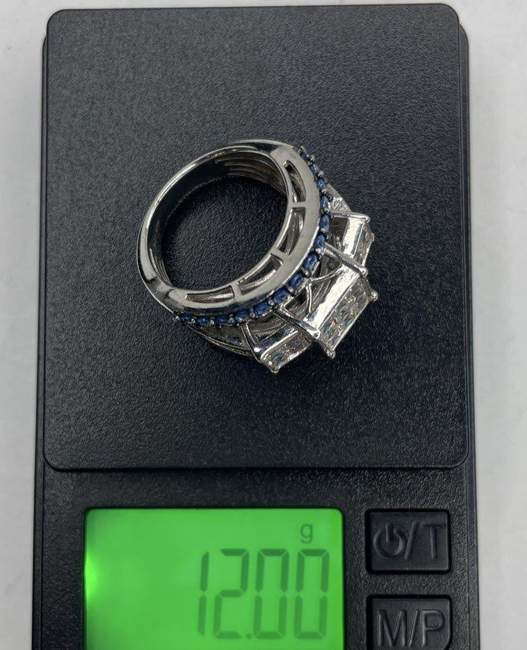 Wide silver tiered cocktail ring with clear baguette and princess-cut stones and blue accents, view 7