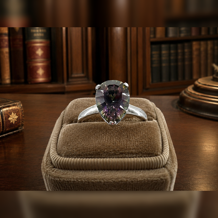 Silver cocktail ring with pear-shaped iridescent stone in prong setting
