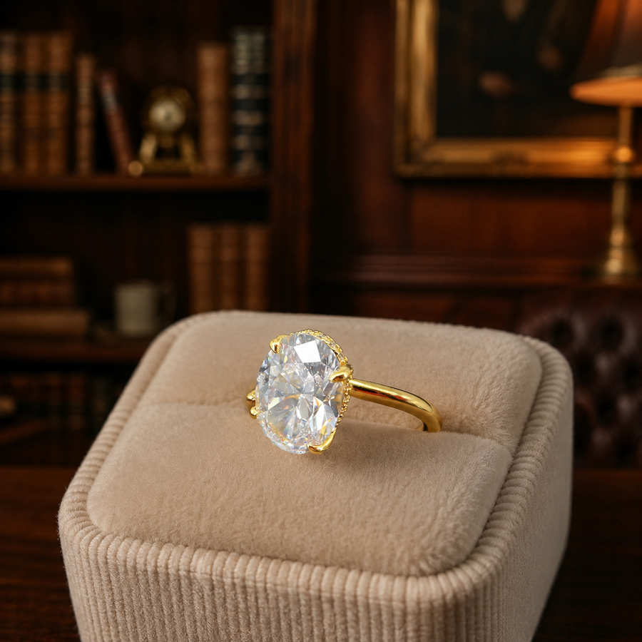 Gold-tone solitaire ring with large oval clear stone in four split prongs