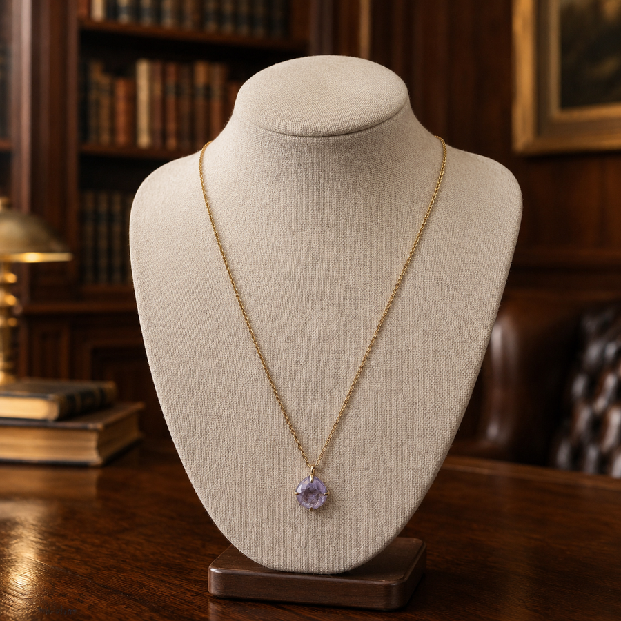 Gold-tone necklace with a single faceted lavender purple crystal pendant