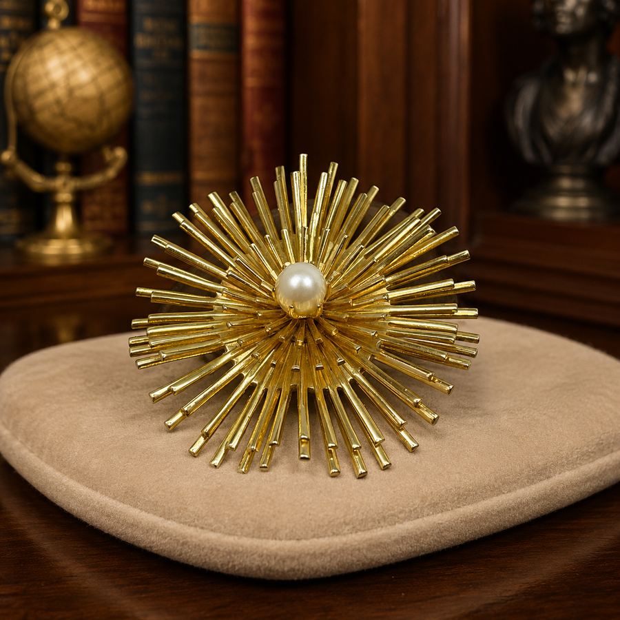 Gold-tone layered sunburst brooch with faux pearl center