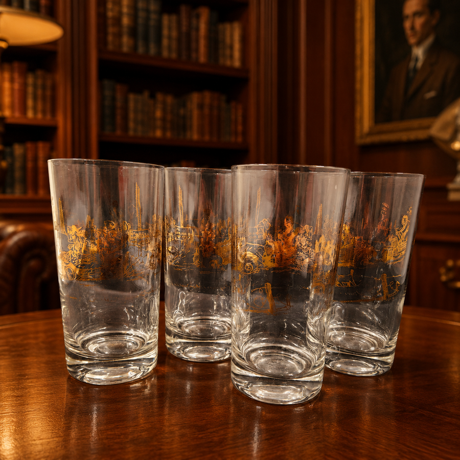 Four clear highball glasses with gold-tone and black early touring automobile scenes