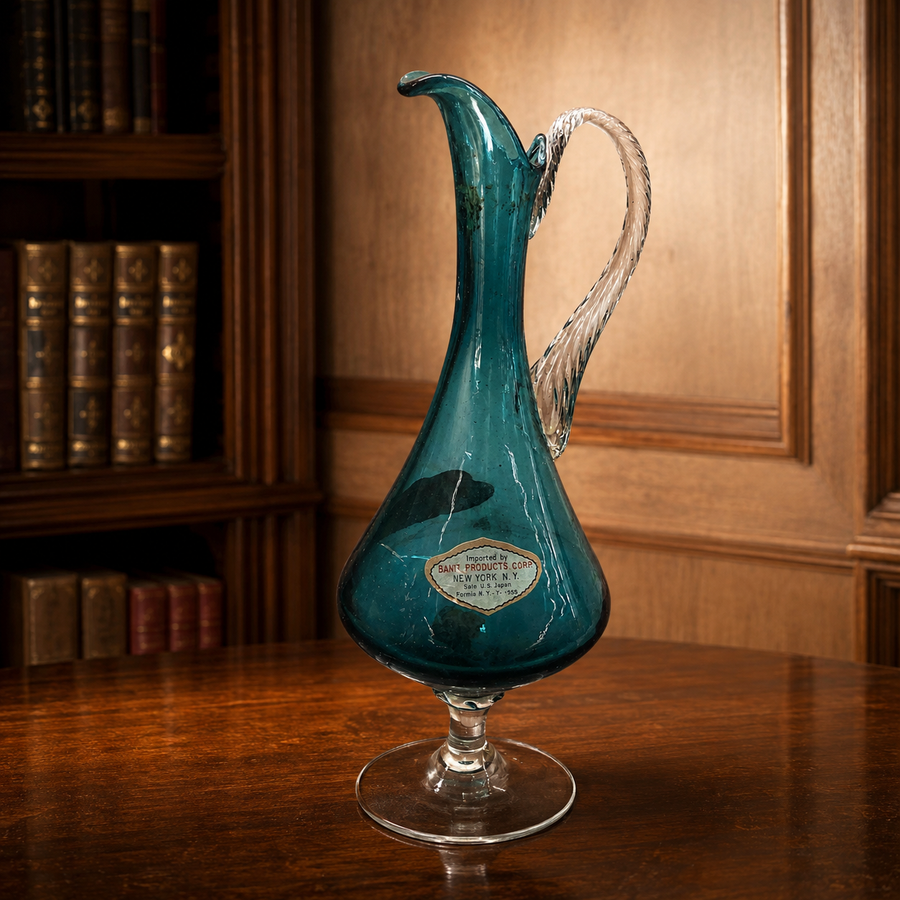 Teal glass ewer with teardrop body, curled lip, clear twisted applied handle and clear foot