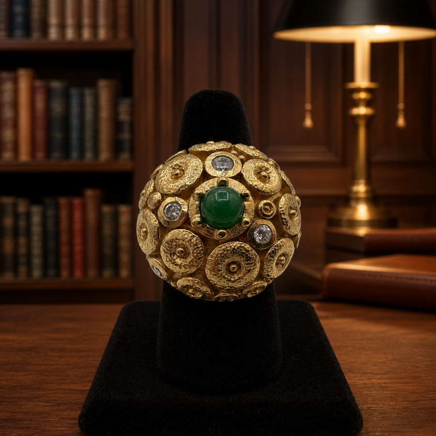 Gold-tone domed statement ring with green cabochon center and cubic zirconia accents