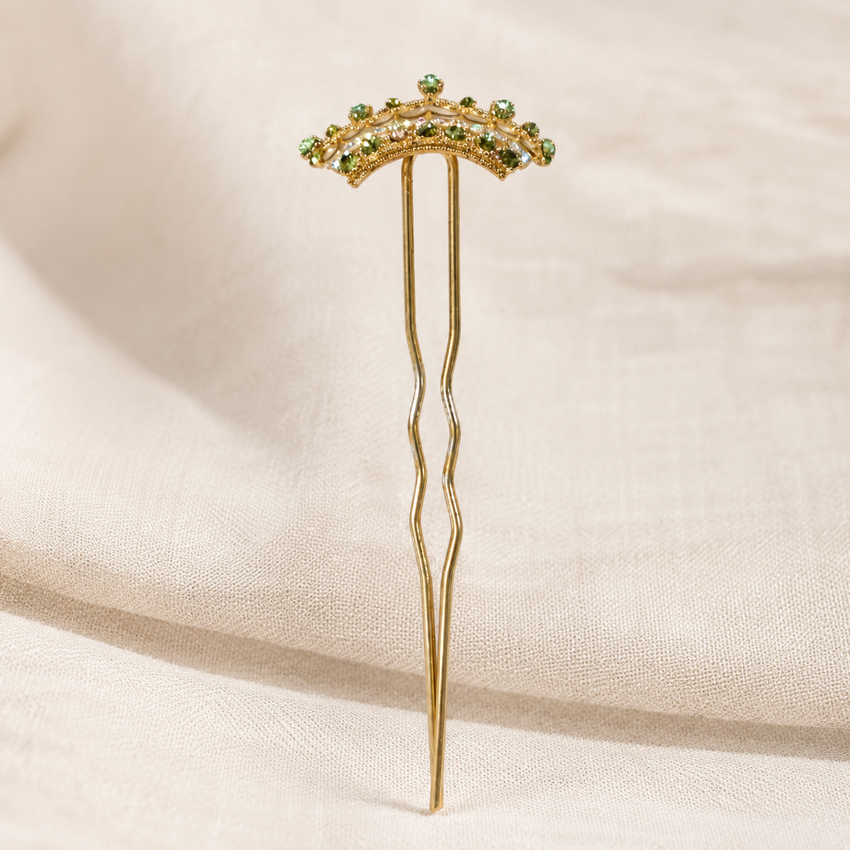 Gold-tone crown bun pick with green and clear rhinestones and twin prongs