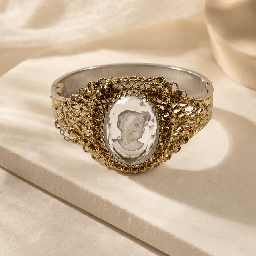 Signed Whiting and Davis gold-tone hinged bracelet with clear intaglio portrait cameo