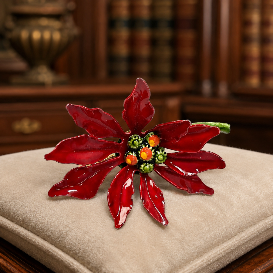 Gold-tone poinsettia brooch with red enamel petals and green enamel leaves