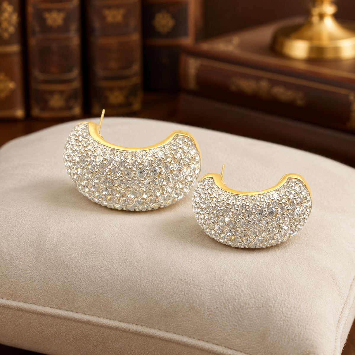 Gold-tone crescent half-hoop earrings with full crystal pavé fronts