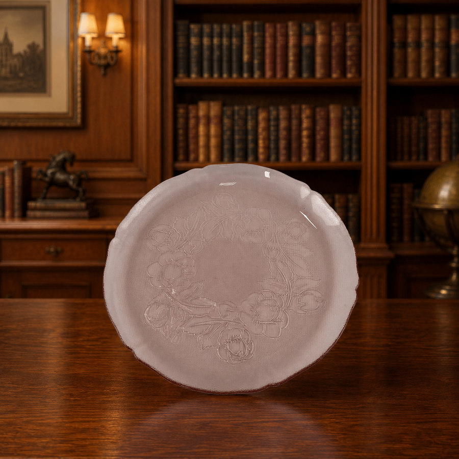 Translucent pink glass platter with scalloped rim and embossed cabbage rose center