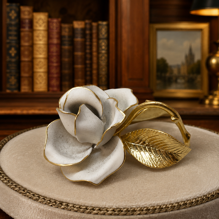 White rose brooch with gold-tone textured leaves and curved stem