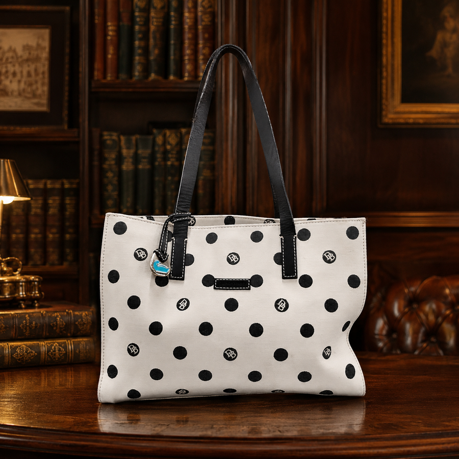 Dooney and Bourke cream canvas tote with black polka dots, black leather straps and blue duck charm