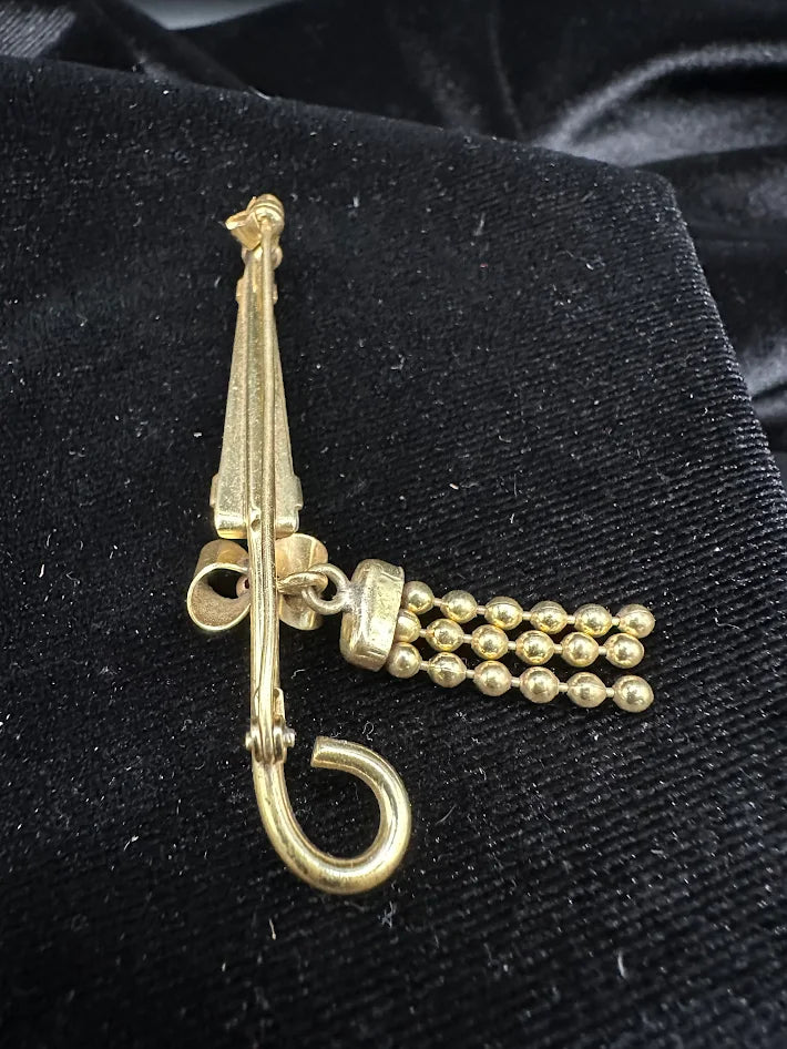 Gold tone umbrella brooch with white carved look panel and bead tassel detail