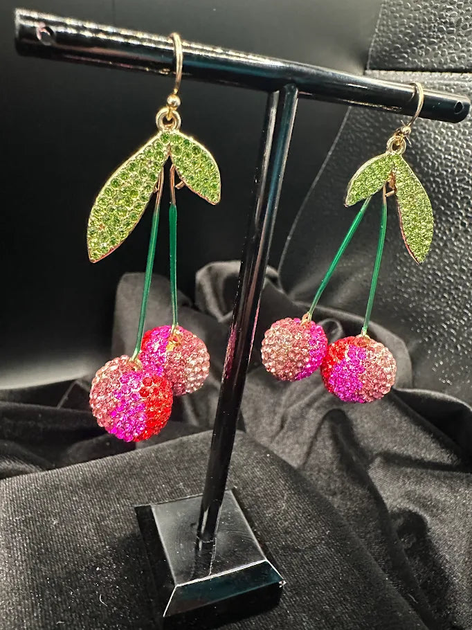 Pink crystal cherry dangle earrings with green stems and leaves on gold-tone hooks, view 3