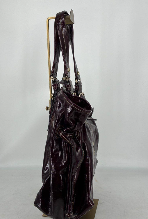 Dooney and Bourke burgundy patent leather tote with drawstring sides and buckle straps, view 3