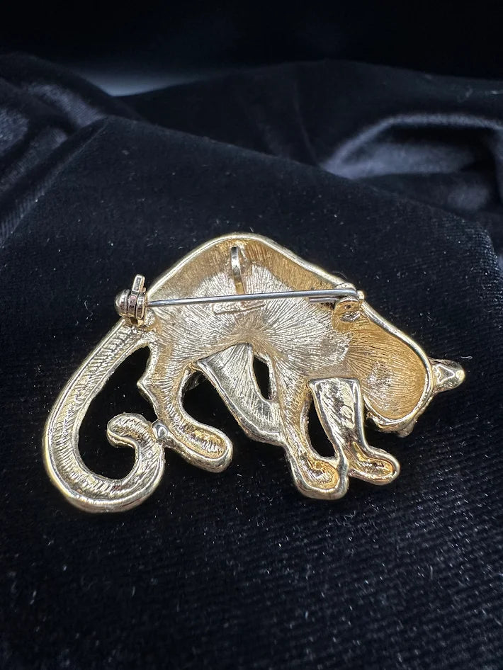 Gold tone leopard brooch with black enamel spots and red eye accent