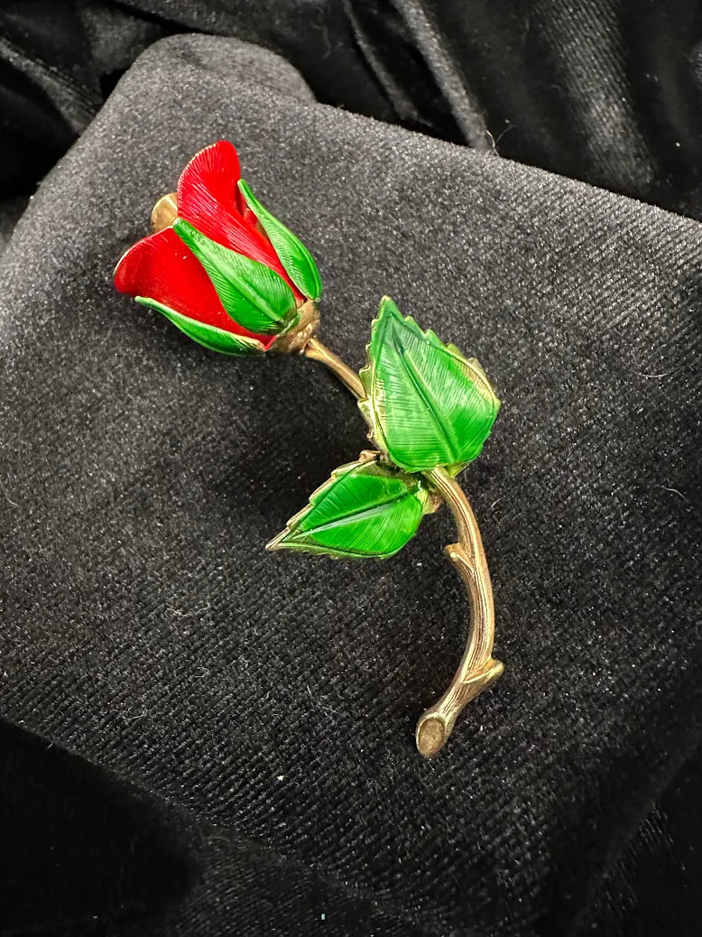 Red enamel rose bud brooch with green enamel leaves on a curved gold-tone stem, view 3