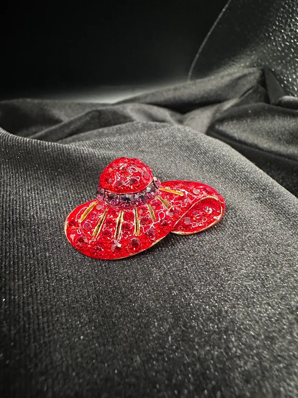 Red crystal hat brooch with curved brim, darker crystal band and gold-tone lines, view 4