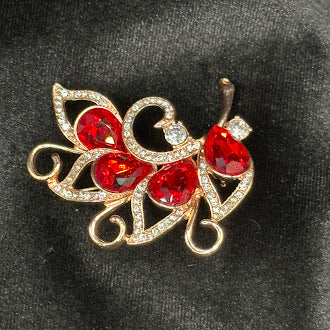 Gold-tone filigree butterfly brooch with red rhinestone wings and clear pavé accents, view 2
