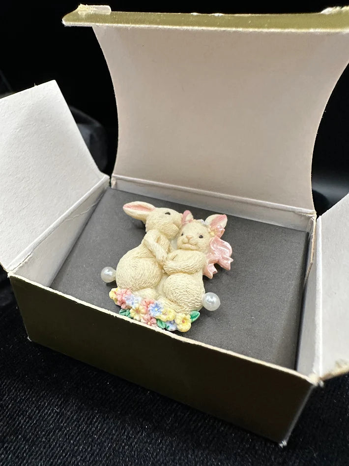 Avon brooch of two cream bunnies on a floral base with faux pearls and pink bow, with Avon box, view 3