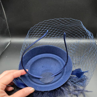 Blue felt pillbox hat with net veil and feather spray