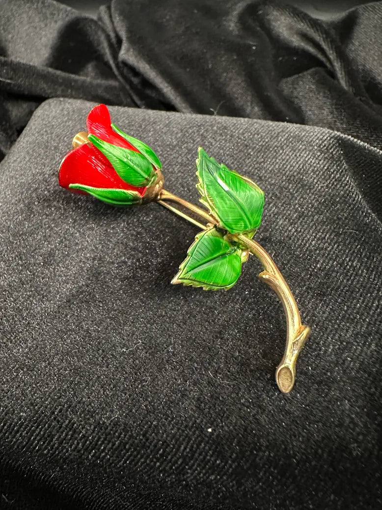 Red enamel rose bud brooch with green enamel leaves on a curved gold-tone stem, view 2