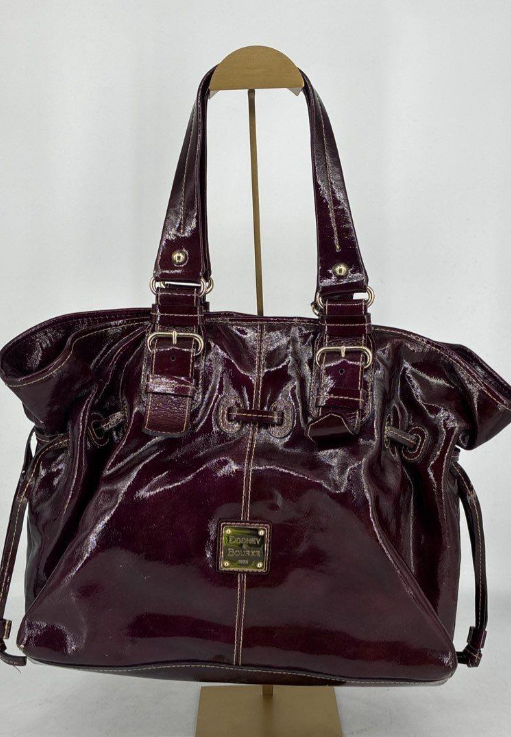 Dooney and Bourke burgundy patent leather tote with drawstring sides and buckle straps, view 2