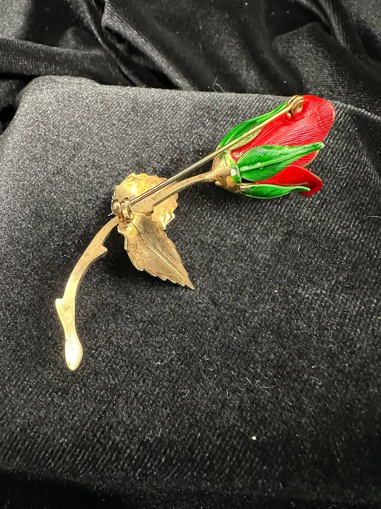 Red enamel rose bud brooch with green enamel leaves on a curved gold-tone stem, view 4