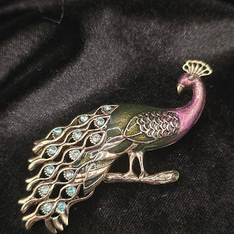 Gold tone enamel peacock brooch with green and purple body and blue stones