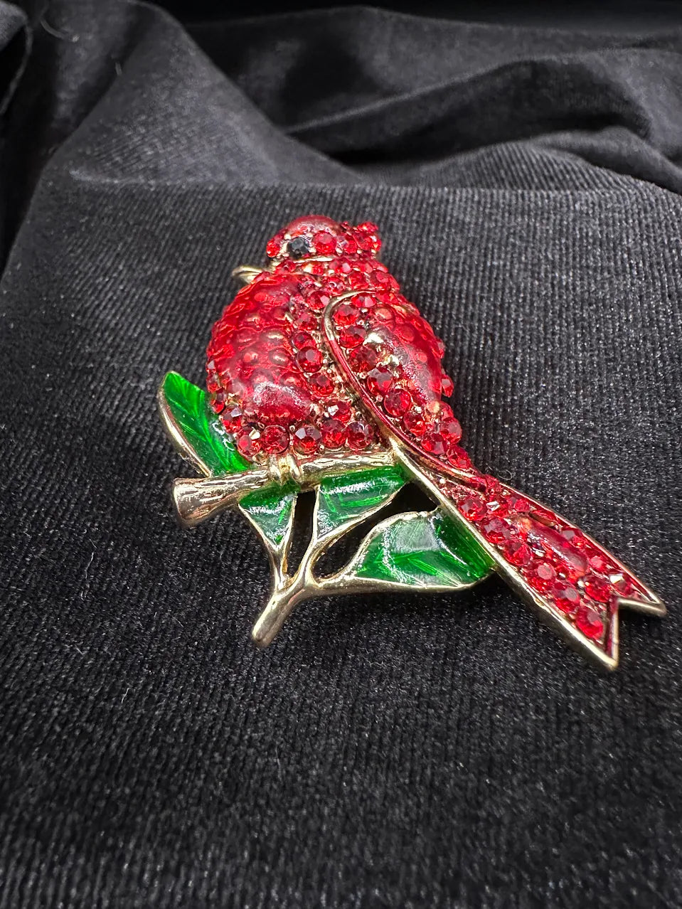 Gold-tone cardinal bird brooch with red crystal body and green enamel-style leaves, view 2