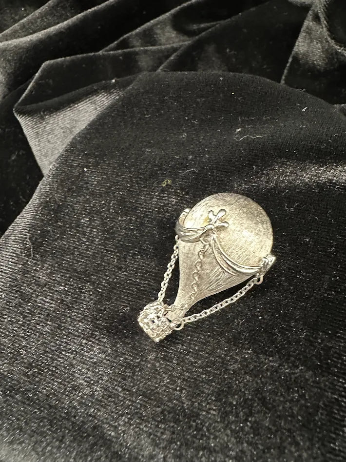 Silver-tone hot air balloon brooch with textured canopy and basket suspended on chains, view 3